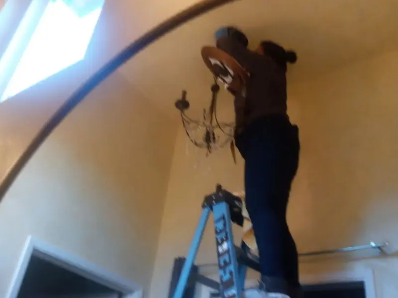 Electrician installing a chandelier in a Whiteriver residence